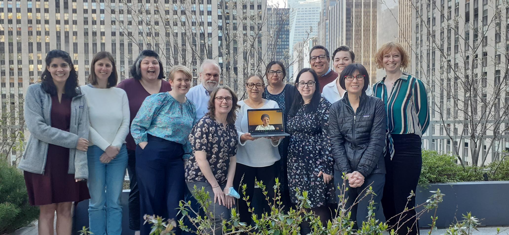 NCLEJ staff pose in a group on a rooftop